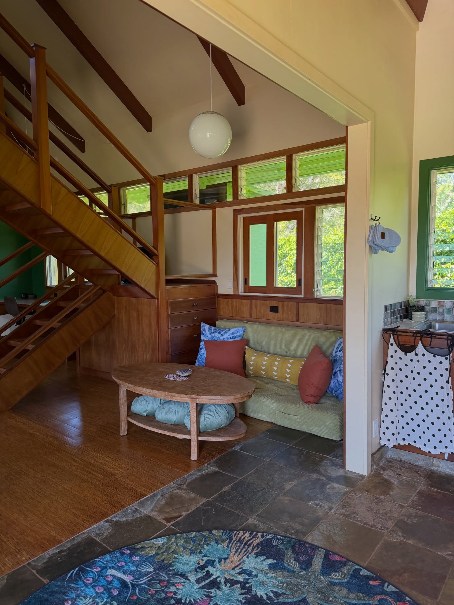 Sun House interior with wood stair, daybed, and garden windows