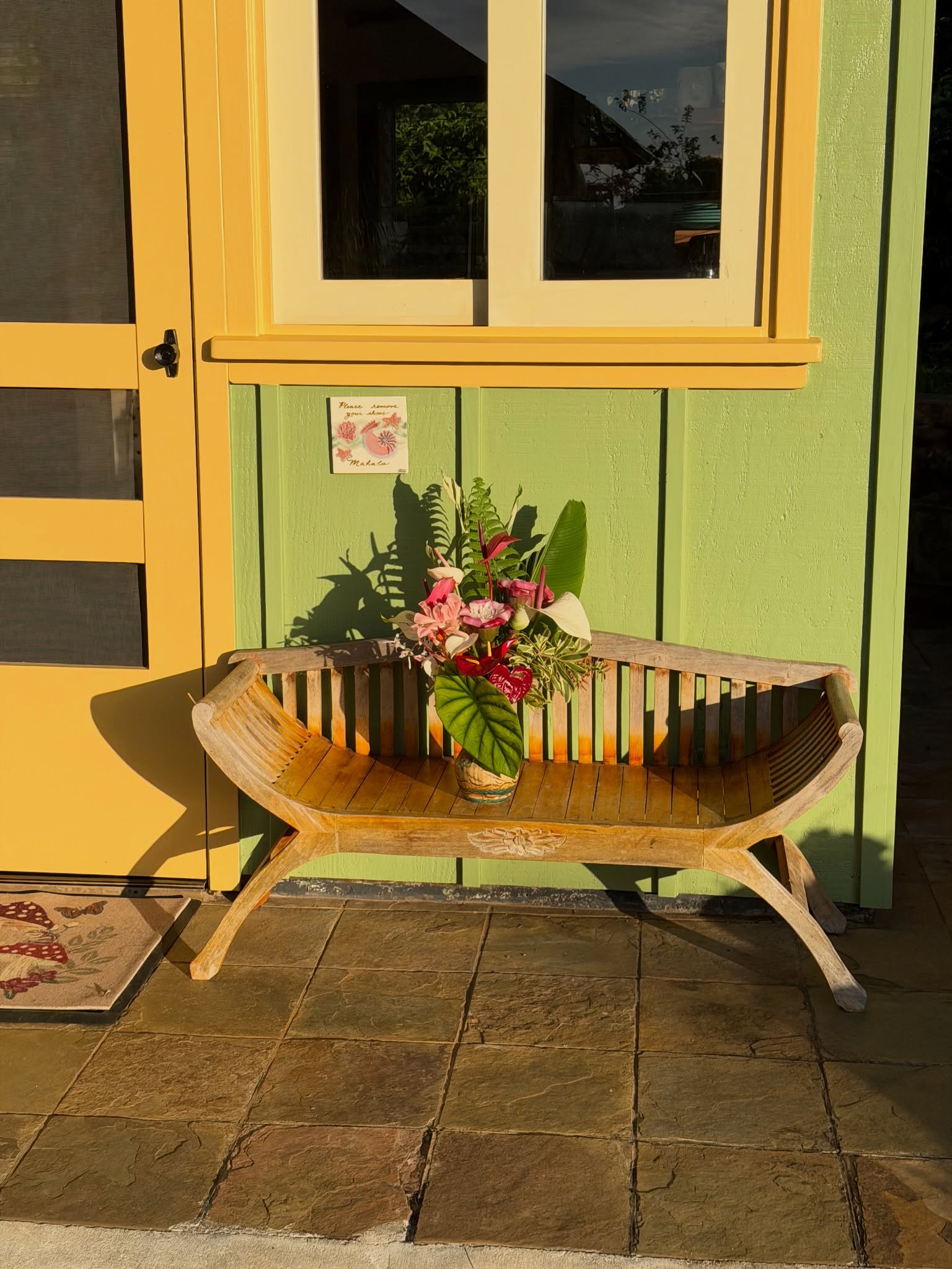 Threshold of campus with flowers on a teak bench