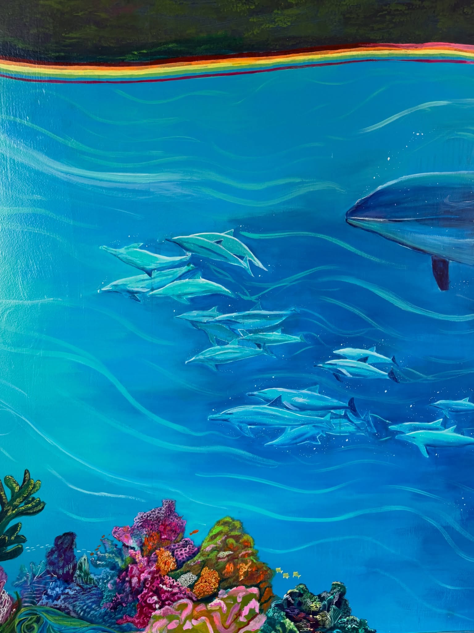Detail of the yoga shala mural with dolphins and coral